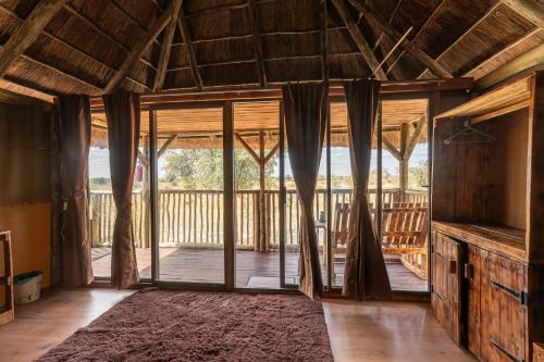 Una sala de estar abierta con puertas corredizas de vidrio. en Chobe Hideaway, en Kasinka