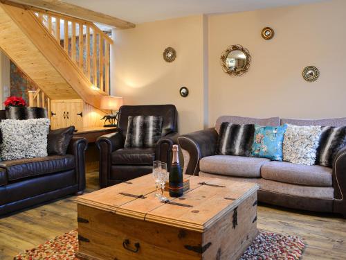 a living room with leather furniture and a wooden coffee table at The Old Forge in Burshill