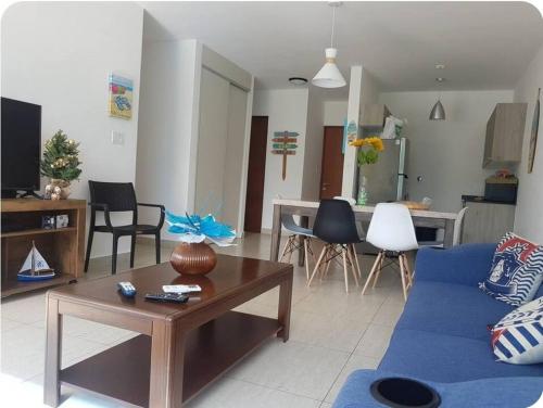 un salon avec un canapé bleu et une table dans l'établissement Playa Blanca Beach and Lagoon Residences, à Cruce del Farallón