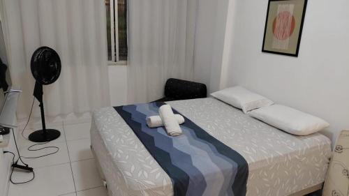 a bedroom with a bed with two white towels on it at Vista da praça Castro Alves in Salvador