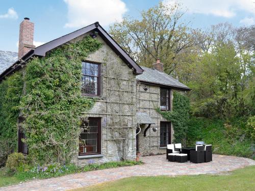 an old stone house with black chairs in front of it at The Farmhouse - Ukc1339 in North Molton