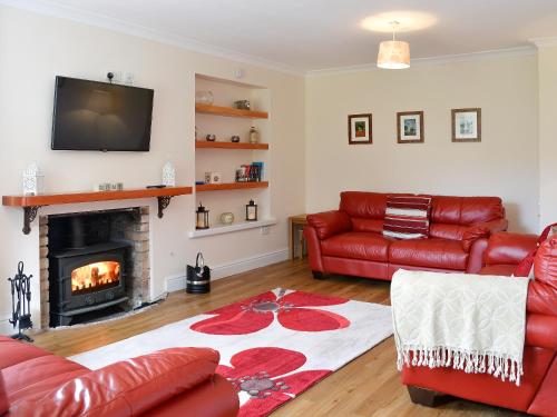 a living room with a couch and a fireplace at The Farmhouse - Ukc1339 in North Molton
