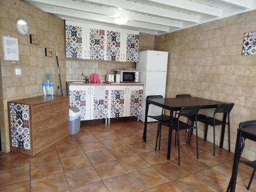 a kitchen with a table and chairs and a refrigerator at MasRelaxTenerife in La Laguna