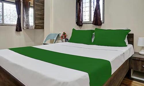 a green and white bed in a room at FabHotel Stay One in Pune