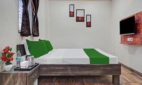 a bedroom with a bed with green and white sheets at FabHotel Stay One in Pune