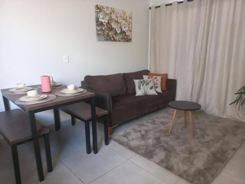 uma sala de estar com um sofá e uma mesa em Perto da área central em Sinop