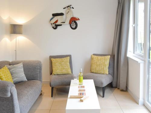 een woonkamer met een bank en een scooter aan de muur bij Happys in St Ives