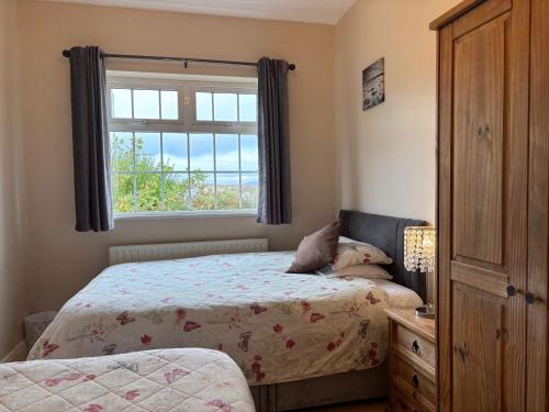 une chambre avec deux lits et une fenêtre dans l'établissement Cottage 494 - Roundstone, à Roundstone