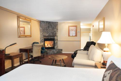 a living room with a couch and a fireplace at Fireside Inn & Suites West Lebanon in West Lebanon