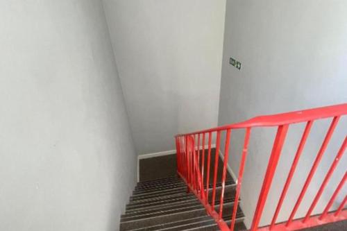 a staircase with a red railing in a room at Hillside Retreat in Wolverhampton in Wolverhampton