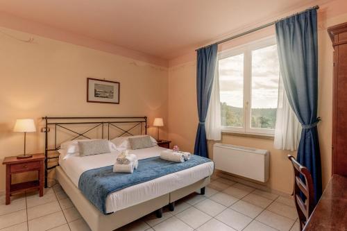 a bedroom with a bed with two stuffed animals on it at Hotiday Toscana Riparbella in Riparbella