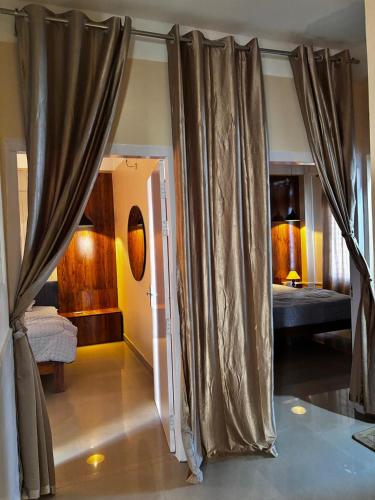 een kamer met gordijnen en een kamer met een slaapkamer bij PANAH luxe in Guwahati