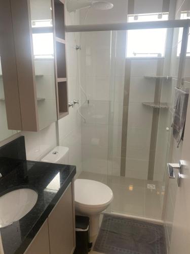ein Badezimmer mit Toilette und Glasdusche in der Unterkunft Sunshine 601 in Balneário Camboriú