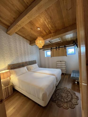 a large white bed in a room with wooden ceilings at HOTEL CASAS DA FORTALEZA Casa do Garda in Outeiro de Rei