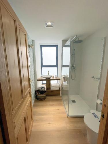 a bathroom with a shower and a toilet and a table at HOTEL CASAS DA FORTALEZA Casa do Garda in Outeiro de Rei