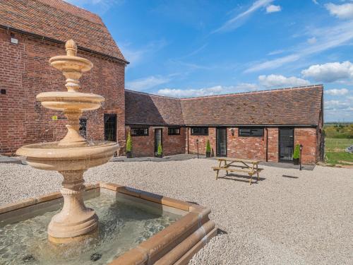 a large fountain in front of a brick building at Corley Rocks Barn - Uk45939 in Corley