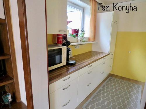 a kitchen with white cabinets and a microwave at Rosental Privatunterkunft in Sankt Margareten im Rosental