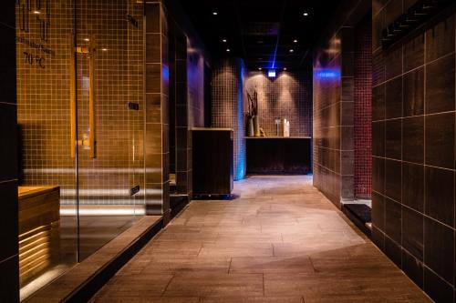 a corridor of a bathroom with a walk in shower at Hotel Skansen Båstad in Båstad