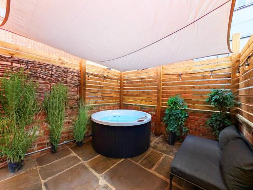 リーズにあるBlayds Yardのホットタブと鉢植えの植物が備わるパティオ