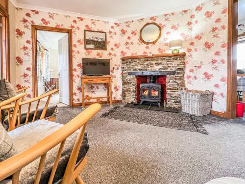ein Wohnzimmer mit Kamin und Fernseher in der Unterkunft Laxdale Cottage in Leverburgh