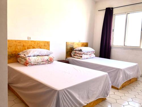 カサブランカにある卡萨布兰卡华人民宿の窓のある部屋にベッドが2つある