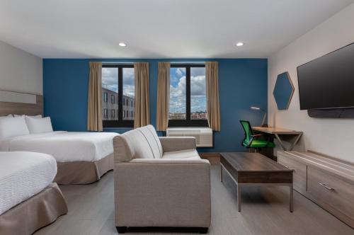 a hotel room with two beds and a flat screen tv at Holiday Inn Express & Suites Bronx - Zoo Area by IHG in Bronx