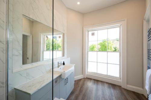 een badkamer met een wastafel en een spiegel bij Windsor Street Apartment in Edinburgh