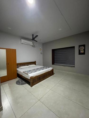 ein Schlafzimmer mit einem Bett und einem Deckenventilator in der Unterkunft Oyster Homes in Munroe Island