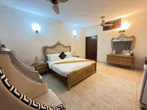 a bedroom with a king sized bed and a couch at MELBERRY Guest House in Islamabad