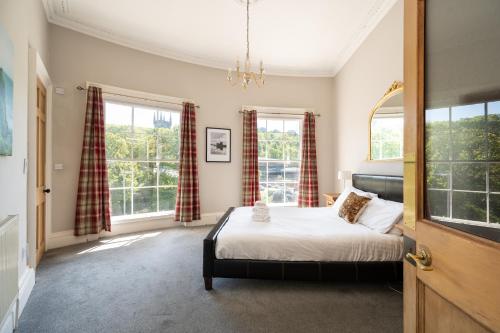 een slaapkamer met een bed en twee ramen bij Windsor Street Apartment in Edinburgh