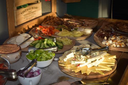 Una mesa con muchos tipos diferentes de comida sobre ella. en Angyal Villa, en Rátka