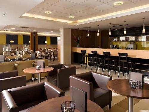 a restaurant with tables and chairs and a bar at Ferenc Hotel Budapest in Budapest