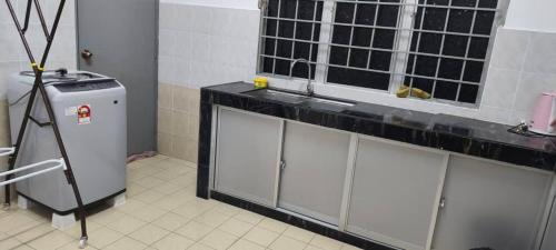 a kitchen with a sink and a window and a refrigerator at BB Senawang Homestay in Seremban
