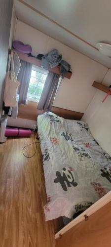 ein kleines Zimmer mit einem Bett und einem Fenster in der Unterkunft Mobil-home climatisé 4 pers 2 chambres in Messanges