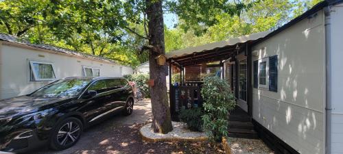ein vor einem Haus geparktes Auto in der Unterkunft Mobil-home climatisé 4 pers 2 chambres in Messanges