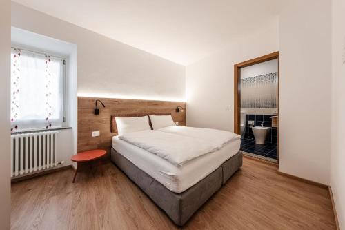 a bedroom with a large bed and a window at Casa Slucca in Pellizzano