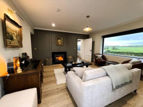 a living room with a white couch and a fireplace at Willow Lodge Cashel- Rock View-Sleeps 8 guests-Spacious- Cosy in Cashel