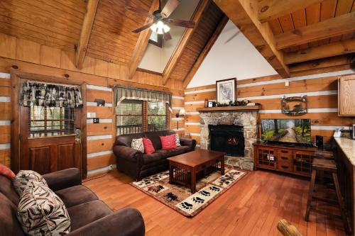 a living room with a couch and a fireplace at Cozy, secluded 2BR cabin with hot tub & pool table only 1 mile from PF parkway! in Pigeon Forge