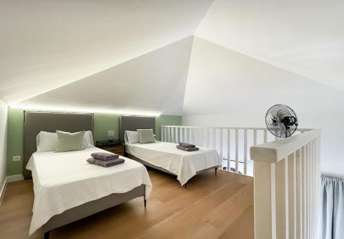 a bedroom with two beds with white sheets at B-Rent Oasis Emma's Suite - 5 People in Corralejo