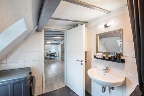 une salle de bain avec un lavabo et un miroir dans l'établissement Am Röntgenmuseum, à Blume