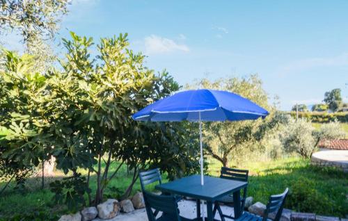 4 Bedroom Stunning Home In Roccastrada في روكاسترادا: طاولة وكراسي زرقاء مع مظلة