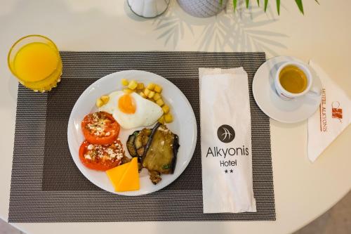 ネア・カリクラティアにあるAlkyonis Hotelのテーブルの上に朝食の皿とコーヒーカップが置かれている
