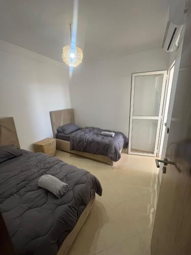 a bedroom with two beds and a window at Appartement 2 chambres meublé Marrakech in Marrakesh