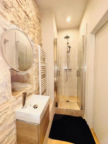 a bathroom with a white sink and a shower at Chez Vivi in Gindou