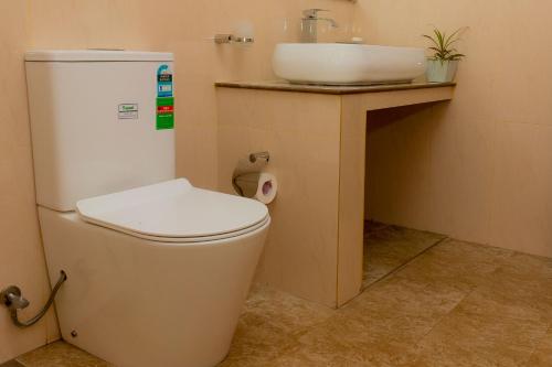 a bathroom with a toilet and a sink at Shasha House Bentota in Hettiwatta