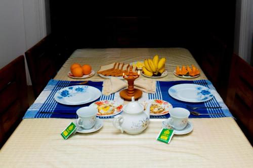 een tafel met borden eten en fruit erop bij Shasha House Bentota in Hettiwatta