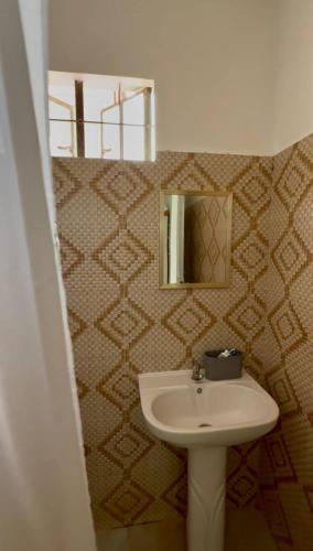 a bathroom with a sink and a mirror at The Meadow View House in Oobi