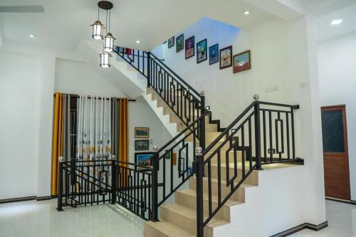 a staircase in a house with black railings at Tropical Haven Villa in Wellawatta