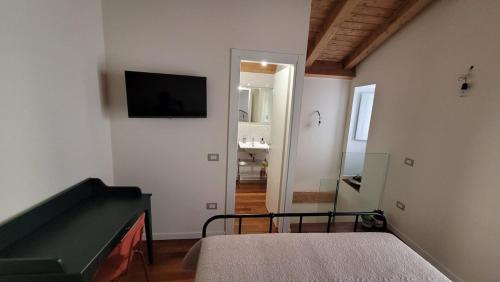 a bedroom with a bed and a flat screen tv on the wall at Little Apartment in Potenza