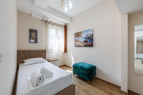 a bedroom with a bed and a painting on the wall at Luma Penthouses by Kondo Stays in Tirana